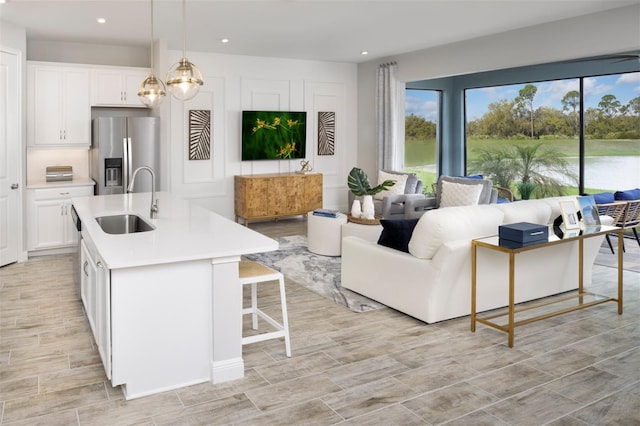 kitchen featuring appliances with stainless steel finishes, a sink, light countertops, white cabinets, and recessed lighting