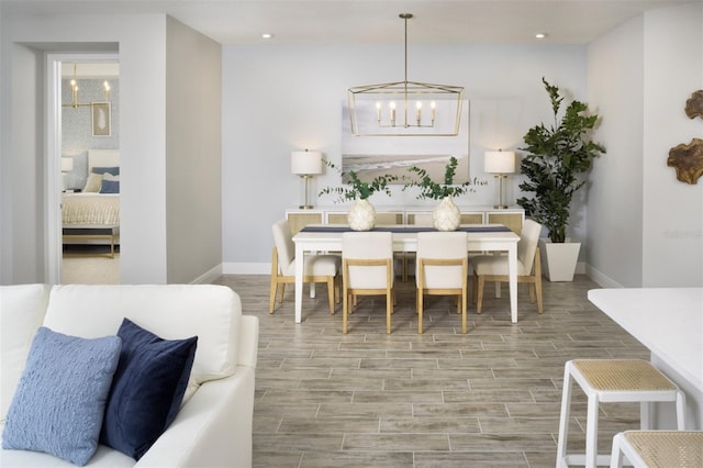 dining room with a chandelier, baseboards, wood finished floors, and recessed lighting