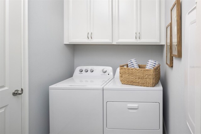 laundry room featuring independent washer and dryer and cabinet space