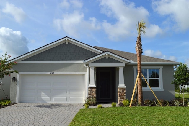 12305 49th St E, Parrish, FL 34219 - craftsman-style home featuring stucco siding, driveway, an attached garage, and a front lawn