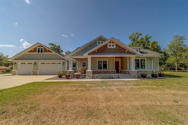 craftsman-style house featuring board and batten siding, a garage, a front yard, a porch, and concrete driveway