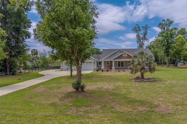 view of front of property featuring concrete driveway, a garage, and covered porch