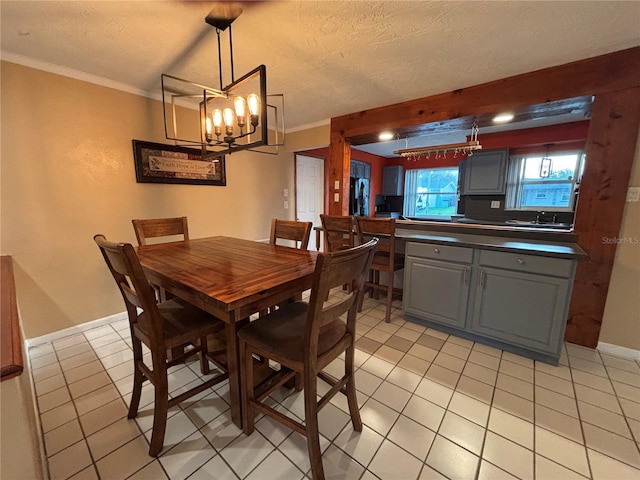 821 Karen St, Palm Harbor, FL 34684 - dining area with a chandelier, light tile patterned flooring, ornamental molding, baseboards, and a textured ceiling