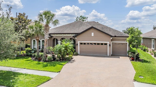 32242 Summerglade Dr, Wesley Chapel, FL 33545 - view of front of house featuring decorative driveway, a garage, a front lawn, and stucco siding