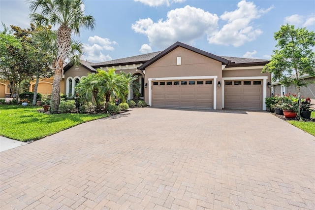 32242 Summerglade Dr, Wesley Chapel, FL 33545 - view of front of home with an attached garage, decorative driveway, a front lawn, and stucco siding