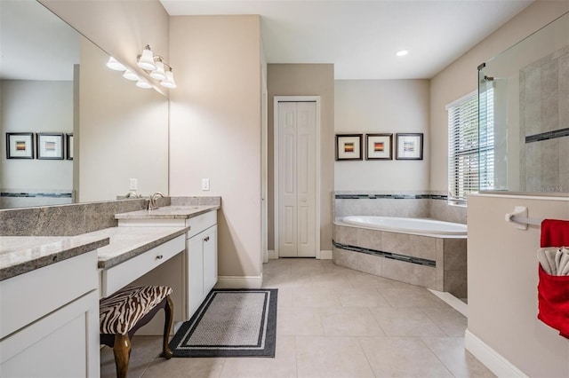 32242 Summerglade Dr, Wesley Chapel, FL 33545 - bathroom featuring a garden tub, tile patterned flooring, vanity, and baseboards