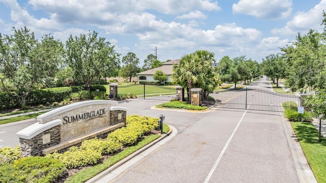 32242 Summerglade Dr, Wesley Chapel, FL 33545 - view of asphalt street with a gate, curbs, and a gated entry