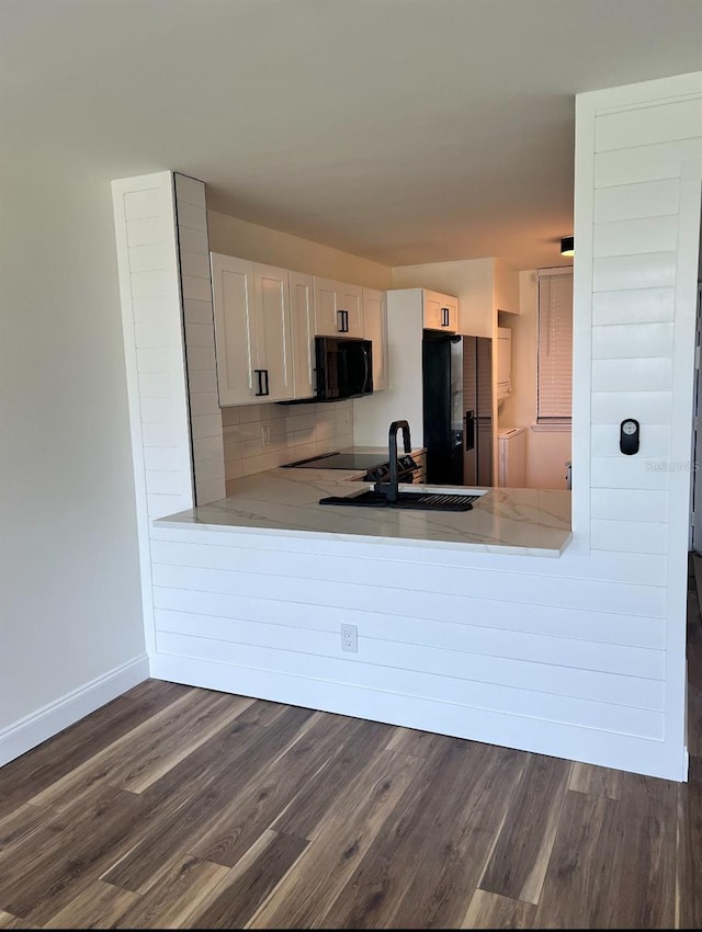 2424 W Tampa Bay Blvd Unit 203, Tampa, FL 33607 - kitchen featuring black appliances, a sink, dark wood-style flooring, baseboards, and white cabinets