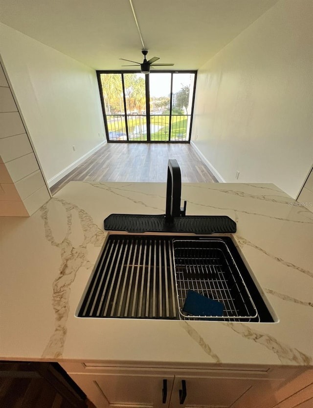 2424 W Tampa Bay Blvd Unit 203, Tampa, FL 33607 - kitchen view of light stone counters, baseboards, and a ceiling fan