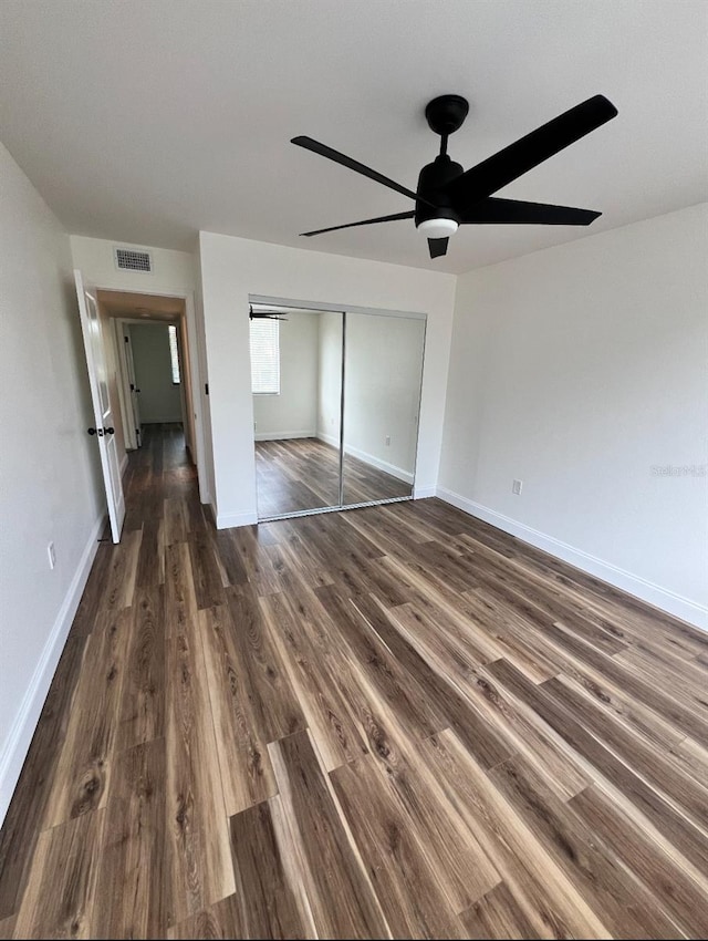 2424 W Tampa Bay Blvd Unit 203, Tampa, FL 33607 - unfurnished bedroom featuring dark wood finished floors, a closet, baseboards, and ceiling fan
