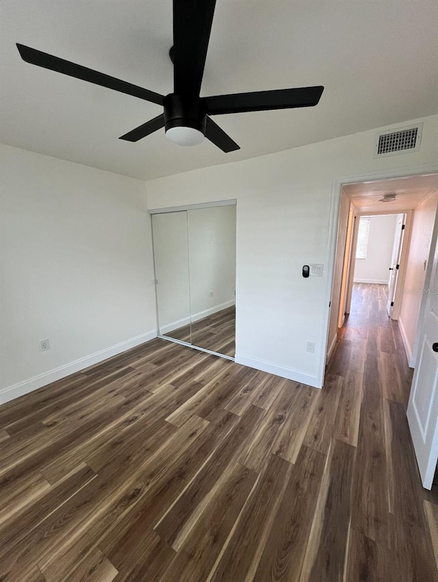 2424 W Tampa Bay Blvd Unit 203, Tampa, FL 33607 - unfurnished bedroom with dark wood-style flooring, a ceiling fan, and baseboards