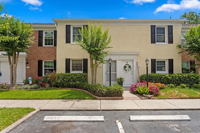 townhome / multi-family property featuring uncovered parking and stucco siding