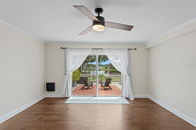 spare room featuring wood finished floors, ornamental molding, a ceiling fan, a textured ceiling, and a water view
