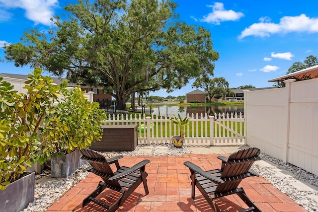 view of patio / terrace with a water view and fence