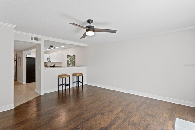 unfurnished living room featuring a ceiling fan, wood finished floors, ornamental molding, baseboards, and recessed lighting
