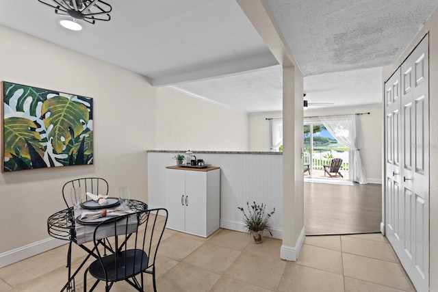 tiled dining space featuring baseboards