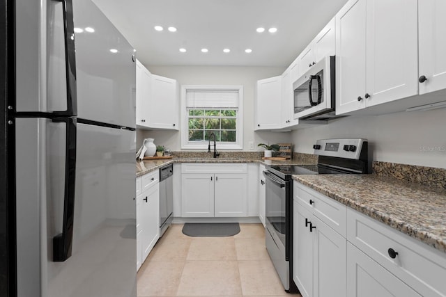 kitchen featuring stainless steel appliances, a sink, recessed lighting, white cabinets, and stone countertops