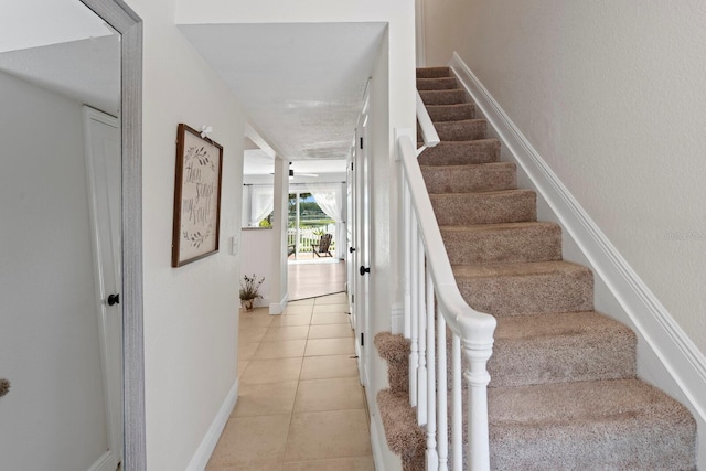 stairway featuring tile patterned flooring and baseboards