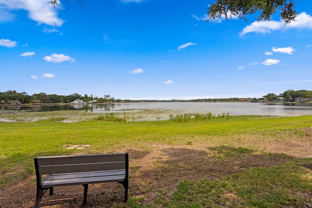 view of green lawn with a water view