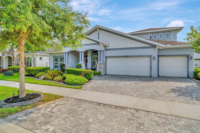 4093 Epic Cv, Land O Lakes, FL 34638 - craftsman-style house featuring decorative driveway, a garage, stucco siding, and stone siding