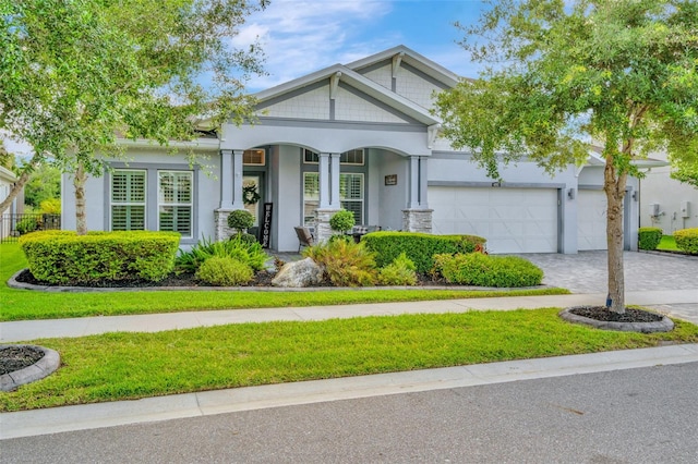 4093 Epic Cv, Land O Lakes, FL 34638 - craftsman-style house featuring decorative driveway, an attached garage, a front lawn, and a porch