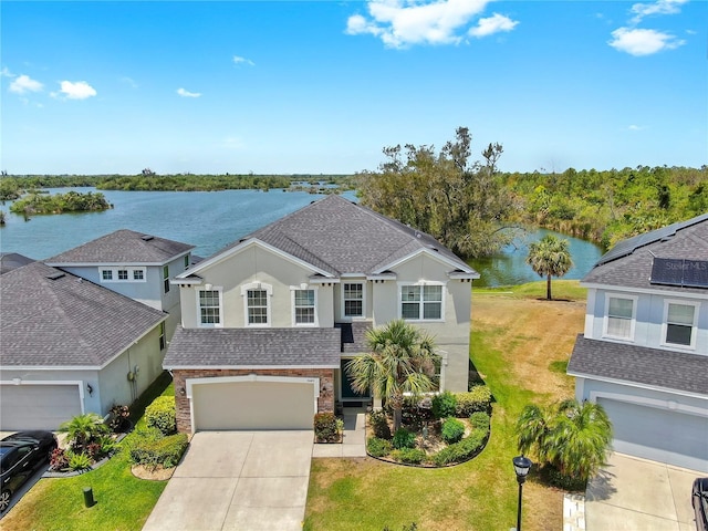 5040 Inshore Landing Dr, Apollo Beach, FL 33572 - traditional-style house with a water view, stucco siding, concrete driveway, and roof with shingles