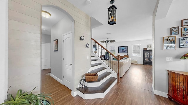5040 Inshore Landing Dr, Apollo Beach, FL 33572 - stairway featuring arched walkways, wood finished floors, and baseboards