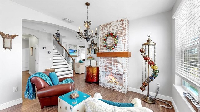 5040 Inshore Landing Dr, Apollo Beach, FL 33572 - living area with arched walkways, a chandelier, wood finished floors, stairway, and baseboards