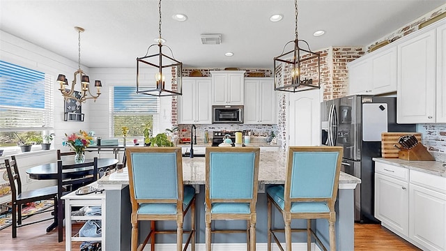 5040 Inshore Landing Dr, Apollo Beach, FL 33572 - kitchen featuring appliances with stainless steel finishes, a chandelier, plenty of natural light, a center island, and recessed lighting