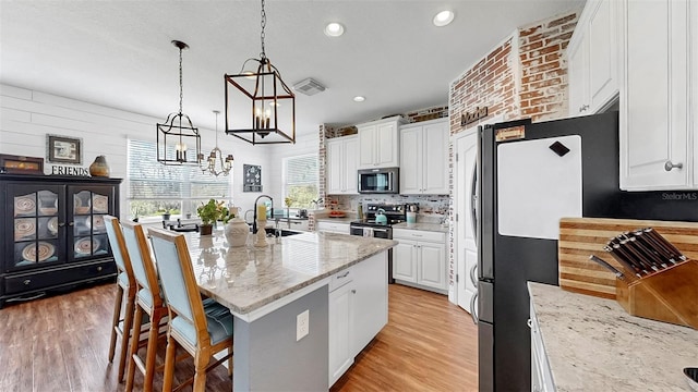 5040 Inshore Landing Dr, Apollo Beach, FL 33572 - kitchen with appliances with stainless steel finishes, a sink, white cabinetry, a chandelier, and recessed lighting