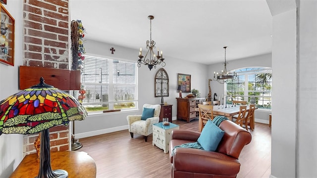 5040 Inshore Landing Dr, Apollo Beach, FL 33572 - living room featuring a chandelier, wood finished floors, and baseboards