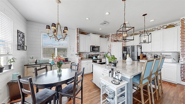5040 Inshore Landing Dr, Apollo Beach, FL 33572 - kitchen with appliances with stainless steel finishes, a chandelier, healthy amount of natural light, light wood finished floors, and recessed lighting
