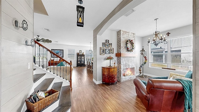 5040 Inshore Landing Dr, Apollo Beach, FL 33572 - entryway featuring baseboards, wood finished floors, a brick fireplace, and arched walkways
