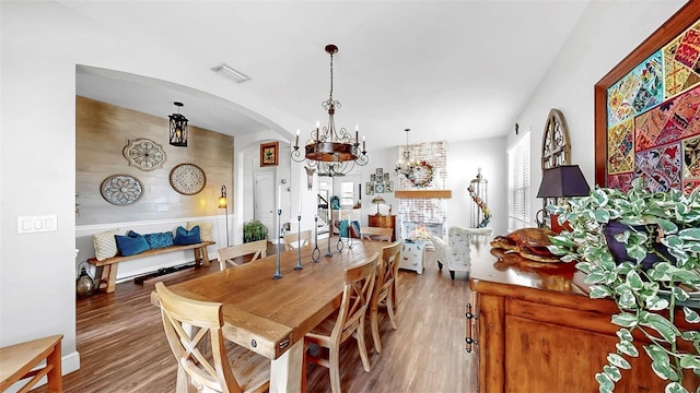5040 Inshore Landing Dr, Apollo Beach, FL 33572 - dining space featuring arched walkways, wood finished floors, and a chandelier