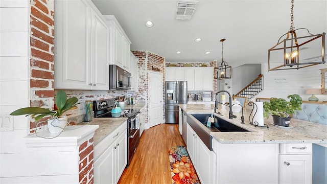 5040 Inshore Landing Dr, Apollo Beach, FL 33572 - kitchen featuring appliances with stainless steel finishes, a chandelier, a sink, recessed lighting, and light wood finished floors