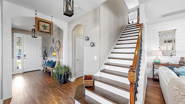 5040 Inshore Landing Dr, Apollo Beach, FL 33572 - foyer featuring arched walkways, wood finished floors, stairs, and wooden walls