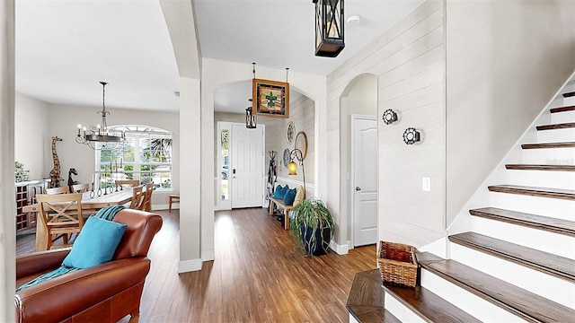 5040 Inshore Landing Dr, Apollo Beach, FL 33572 - entryway with wood finished floors, arched walkways, a chandelier, baseboards, and stairway