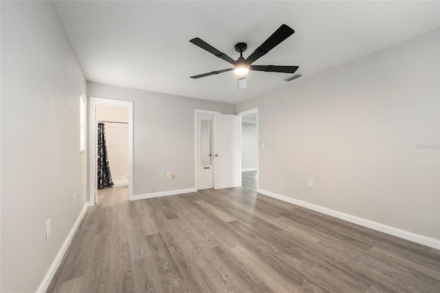 unfurnished bedroom featuring wood finished floors, baseboards, and a ceiling fan