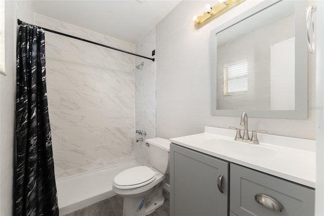 bathroom featuring toilet, tiled shower, vanity, and wood finished floors
