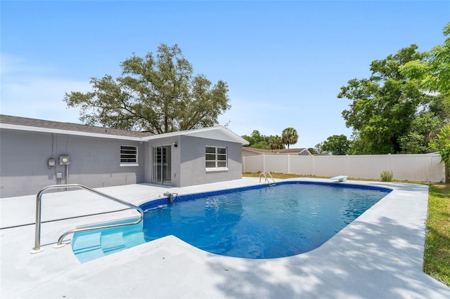 view of swimming pool featuring a patio and fence