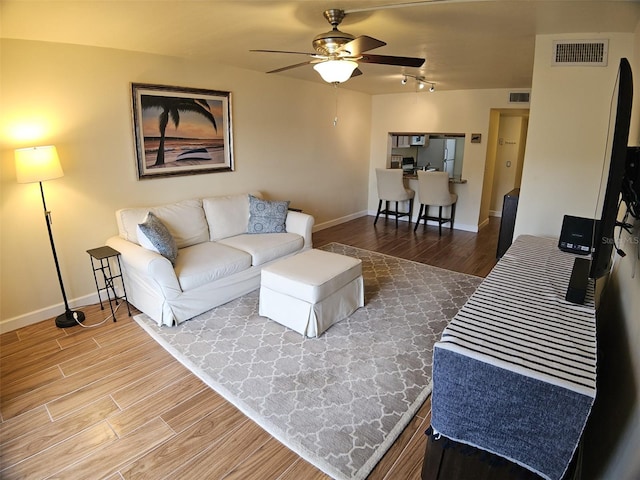 10003 Winding Lake Rd Unit 105, Sunrise, FL 33351 - living room with wood finished floors, a ceiling fan, baseboards, and rail lighting
