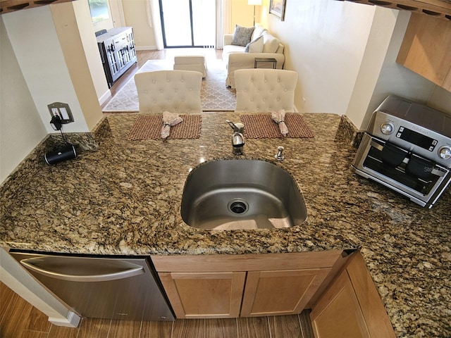 10003 Winding Lake Rd Unit 105, Sunrise, FL 33351 - kitchen view of dark stone counters, a sink, and brown cabinetry