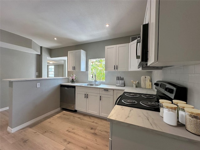 1536 S Martin Luther King Jr Ave, Clearwater, FL 33756 - kitchen with stainless steel appliances, a sink, backsplash, light wood finished floors, and white cabinetry