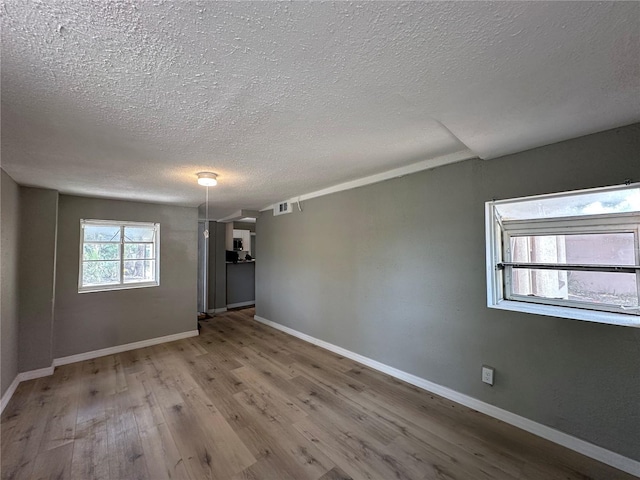 1536 S Martin Luther King Jr Ave, Clearwater, FL 33756 - empty room featuring a textured ceiling, wood finished floors, and baseboards