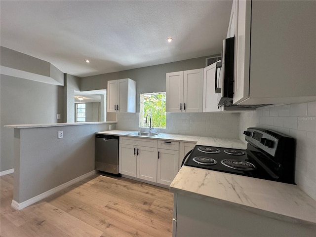 1536 S Martin Luther King Jr Ave, Clearwater, FL 33756 - kitchen with appliances with stainless steel finishes, a sink, backsplash, light wood-style floors, and white cabinets