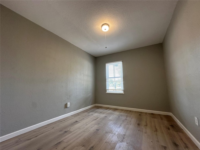 1536 S Martin Luther King Jr Ave, Clearwater, FL 33756 - empty room with wood finished floors, baseboards, a textured wall, and a textured ceiling