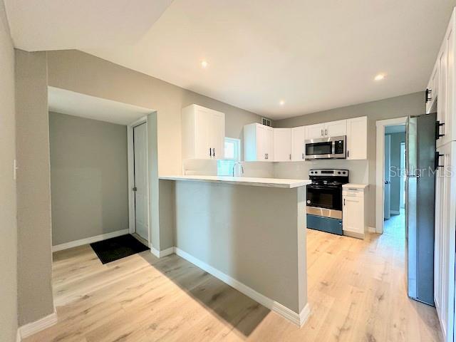 1536 S Martin Luther King Jr Ave, Clearwater, FL 33756 - kitchen with appliances with stainless steel finishes, light wood-style floors, white cabinets, light countertops, and recessed lighting