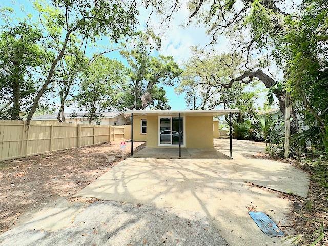 1536 S Martin Luther King Jr Ave, Clearwater, FL 33756 - back of property with a fenced backyard, stucco siding, and a patio