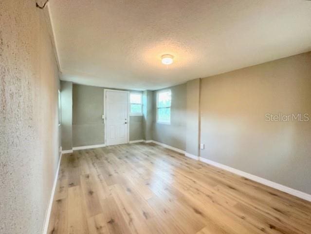 1536 S Martin Luther King Jr Ave, Clearwater, FL 33756 - unfurnished bedroom with wood finished floors, a textured ceiling, and baseboards