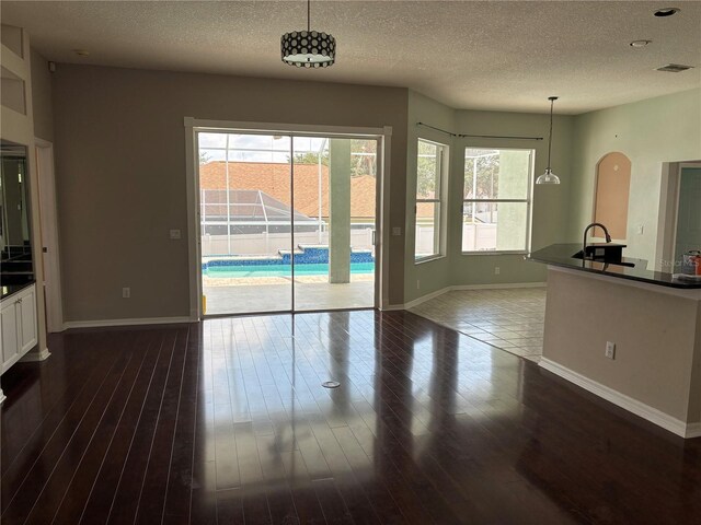 4512 River Overlook Dr, Valrico, FL 33596 - unfurnished dining area featuring baseboards, a textured ceiling, plenty of natural light, and dark wood-style flooring